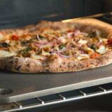 Een standaard pizzasteen gemaakt van staal in een oven