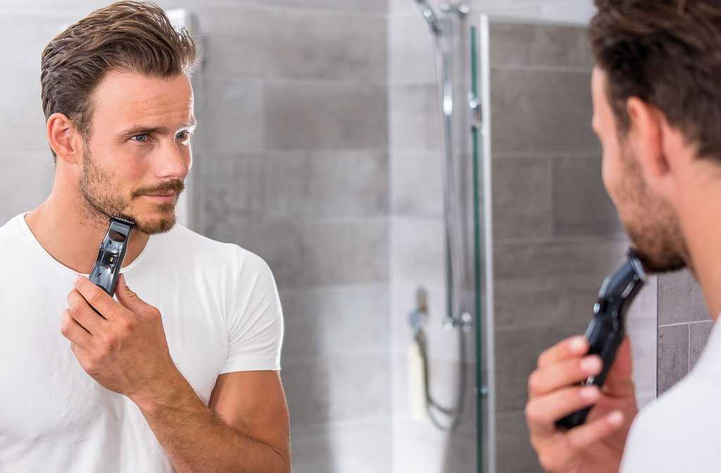 Man gebruikt een van de beste baardtrimmers in de spiegel